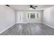 Bright living room featuring elegant wood-look floors, a front door and a large window for natural light at 11176 3Rd Ave, Punta Gorda, FL 33955