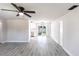 Open-concept living room with wood-look floors, white walls, ceiling fan, and views into the kitchen at 11176 3Rd Ave, Punta Gorda, FL 33955