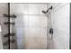 Shower featuring gray tile, a sleek shower head, and practical shelving for organization at 11176 3Rd Ave, Punta Gorda, FL 33955