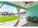 Covered patio with brick flooring, outdoor furniture, and views of the green lawn, boat dock, and pool at 11723 1St E St, Treasure Island, FL 33706