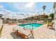 Community pool area featuring lounge chairs and tables with views of the waterfront and residential buildings at 11723 1St E St, Treasure Island, FL 33706