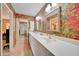 Spacious bathroom featuring double sinks, large mirrors, and stylish wallpaper at 1200 Winward Ct, Punta Gorda, FL 33950