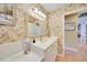 Neutral-toned bathroom vanity with marble top and large well-lit mirror at 1200 Winward Ct, Punta Gorda, FL 33950