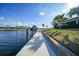 Waterfront view from dock featuring a boat lift and palm trees against a bright blue sky at 1200 Winward Ct, Punta Gorda, FL 33950