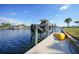 Boat lift and dock on waterfront property with vibrant blue sky and boat at 1200 Winward Ct, Punta Gorda, FL 33950