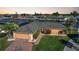 Aerial view of a charming single-story home featuring a brick driveway, tile roof, and well-maintained landscaping at 1200 Winward Ct, Punta Gorda, FL 33950