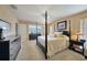 Elegant main bedroom with a four-poster bed, complemented by water views and natural light at 1200 Winward Ct, Punta Gorda, FL 33950