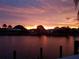 Stunning waterfront view with vibrant sunset colors and lush tropical foliage at 1200 Winward Ct, Punta Gorda, FL 33950