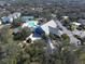 Aerial view of the community clubhouse and pool, surrounded by trees and tennis court at 1286 Green Oak Trl, Port Charlotte, FL 33948