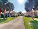 View of a paved driveway leading up to two residences surrounded by palm trees at 1286 Green Oak Trl, Port Charlotte, FL 33948