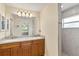 Spacious bathroom featuring a double vanity, granite countertop, and tiled shower at 13157 Ridgely Cir, Port Charlotte, FL 33981