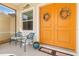 Close up of the covered entryway featuring a seating area and decorative wreaths on the double front door at 13157 Ridgely Cir, Port Charlotte, FL 33981