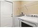 Bright laundry room with modern washer and dryer, plus storage shelf at 13157 Ridgely Cir, Port Charlotte, FL 33981