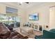 Living room with a comfortable leather sofa, large TV, and sliding glass doors to the patio at 13157 Ridgely Cir, Port Charlotte, FL 33981