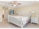 Well-lit bedroom with a comfortable bed, ceiling fan, and tiled floor at 13157 Ridgely Cir, Port Charlotte, FL 33981