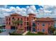 Stunning multi-story building featuring a unique design, a red tile roof and lush tropical landscaping at 1344 Mediterranean Dr # 121, Punta Gorda, FL 33950