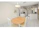 Cozy dining area with a wooden table, white chairs, and bright lighting adjacent to kitchen at 1364 Ultramarine Ln, Punta Gorda, FL 33983