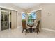 Breakfast nook with glass table and view of screened-in pool and tropical foliage at 1453 Wren Ct, Punta Gorda, FL 33950