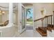 Bright foyer features decorative glass front door, wooden staircase, and tile flooring that leads into the home at 1453 Wren Ct, Punta Gorda, FL 33950