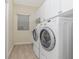 A well-organized laundry room features white cabinets and modern washer and dryer units at 1453 Wren Ct, Punta Gorda, FL 33950