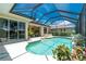 Exterior view of the screened-in pool, integrated with the lanai, lush backyard and outdoor living area at 1453 Wren Ct, Punta Gorda, FL 33950