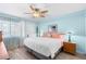 Bright bedroom features a ceiling fan, light blue walls, wood laminate floors, and natural light from the window at 150 Harborside Ave # 122, Punta Gorda, FL 33950