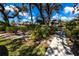 Landscaped path leading to a well-maintained home with mature trees at 1515 Forrest Nelson Blvd # D103, Port Charlotte, FL 33952