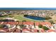 Aerial view of townhomes, highlighting the red tile roofs and proximity to a community lake and golf course at 1640 Atares Dr # 21, Punta Gorda, FL 33950