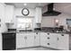 Close-up of the kitchen features white cabinets, granite countertops, a stainless steel sink, and modern black appliances at 19179 Aviation Ct, Port Charlotte, FL 33948