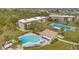 Overhead view showing community pool, clubhouse, tennis courts, and beautifully landscaped surroundings at 1999 Kings Hwy # 21A, Punta Gorda, FL 33980