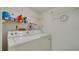 Functional laundry room with shelving above the washer and dryer hookups at 1999 Kings Hwy # 21A, Punta Gorda, FL 33980