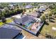 An aerial view showcases a home with a screened pool, pergola, and manicured yard in a residential neighborhood at 23144 Donalda Ave, Port Charlotte, FL 33954