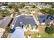 Aerial view of a single-story house with a large yard, a screened-in pool, and a well-manicured lawn at 23144 Donalda Ave, Port Charlotte, FL 33954