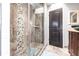 Modern bathroom with glass-enclosed shower featuring decorative stone accents and tile surround at 23144 Donalda Ave, Port Charlotte, FL 33954