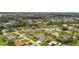 Aerial view of a single-Gathering home with a large lot surrounded by lush greenery and other homes at 23411 Superior Ave, Port Charlotte, FL 33954