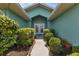 Inviting front entrance framed by lush greenery, leading to a welcoming double-door entry at 23411 Superior Ave, Port Charlotte, FL 33954