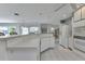 Bright open kitchen featuring white appliances, counter seating, and tiled floors at 23411 Superior Ave, Port Charlotte, FL 33954