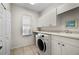 Efficient laundry room with modern appliances and storage cabinets at 237 Freeport Ct, Punta Gorda, FL 33950