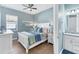 Inviting bedroom showcasing a white bed frame and blue accents, illuminated by a ceiling fan at 25197 Keygrass Ct, Punta Gorda, FL 33955