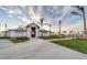 Exterior view of a modern, light-colored clubhouse with palm trees and a well-manicured lawn at 25197 Keygrass Ct, Punta Gorda, FL 33955