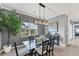 Modern dining room with glass table, stylish chandelier, and serene views from the nearby window at 25197 Keygrass Ct, Punta Gorda, FL 33955