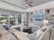 Stylish living room with a modern ceiling fan, textured accent wall, and sliding glass doors leading to the pool area at 25197 Keygrass Ct, Punta Gorda, FL 33955