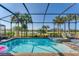 Inviting screened-in pool and hot tub area with lush landscaping and serene lake views at 25197 Keygrass Ct, Punta Gorda, FL 33955