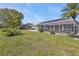 Expansive backyard with a screened pool enclosure, mature trees, and landscaping at 27566 Tierra Del Fuego Cir, Punta Gorda, FL 33983