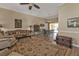 Living room featuring a large rug, sitting furniture, and a view into the dining room and pool at 27566 Tierra Del Fuego Cir, Punta Gorda, FL 33983