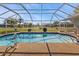 Inviting screened-in pool and patio surrounded by a well-manicured lawn at 27566 Tierra Del Fuego Cir, Punta Gorda, FL 33983