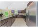 Well-lit kitchen features dark wood cabinetry, stainless steel appliances, and granite countertops with island at 2851 Verde Ter, North Port, FL 34286