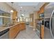 A kitchen with stainless steel appliances, wood cabinets, a tile floor, and a view into the living room at 295 Porto Alegre St, Punta Gorda, FL 33983