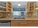 Kitchen area with stone countertops, wood cabinets and a stainless steel dishwasher overlooking the pool at 295 Porto Alegre St, Punta Gorda, FL 33983