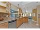 Bright kitchen featuring wood cabinetry, granite counters, tile backsplash, and stainless steel dishwasher at 295 Porto Alegre St, Punta Gorda, FL 33983